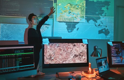IT manager in front of map projections in computer room to symbolize data leakage